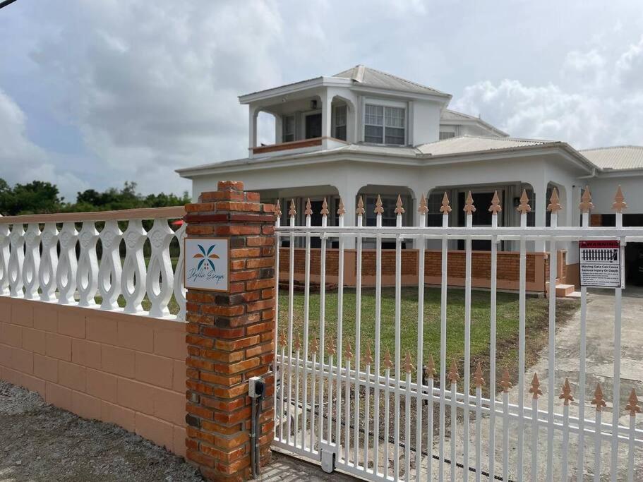 a white fence in front of a house at Unwind at Idyllic Escape! in Dickenson Bay