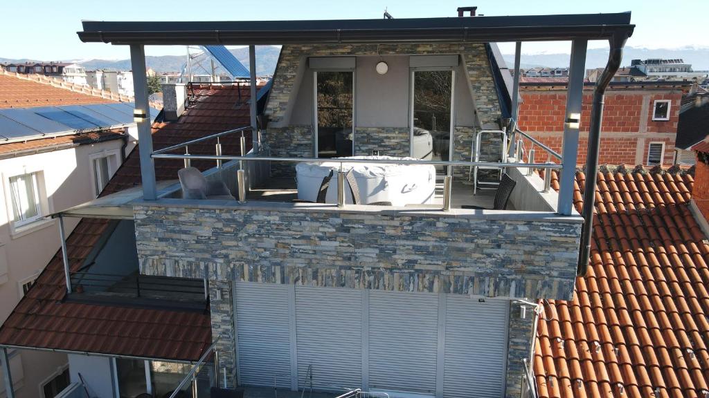 a house on a roof with a patio and a balcony at Hotel New York Struga in Struga