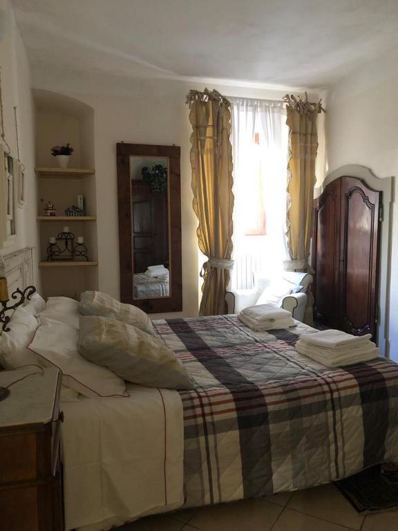 Un dormitorio con una cama grande y una ventana en Torri e Campanili, en Ascoli Piceno