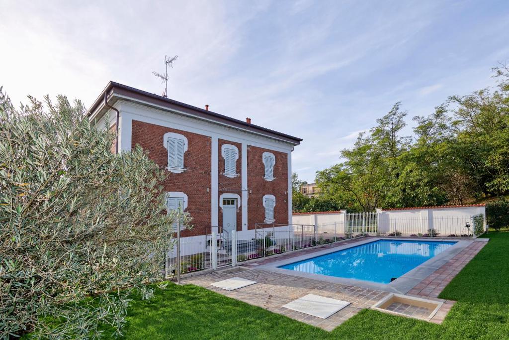 una casa de ladrillo con piscina en el patio en La Villa en Novara