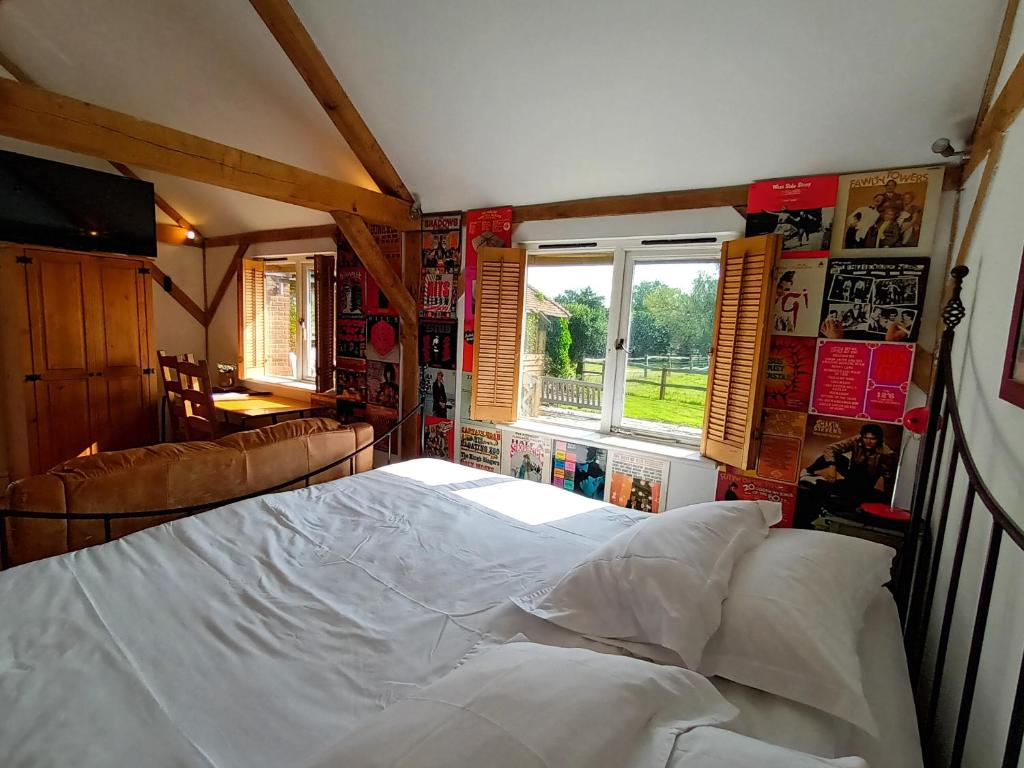 a bedroom with a large white bed and a window at The Music Room - Kingsize Double Oak Studio - Sleeps 2 - Quirky - Rural in Haslemere