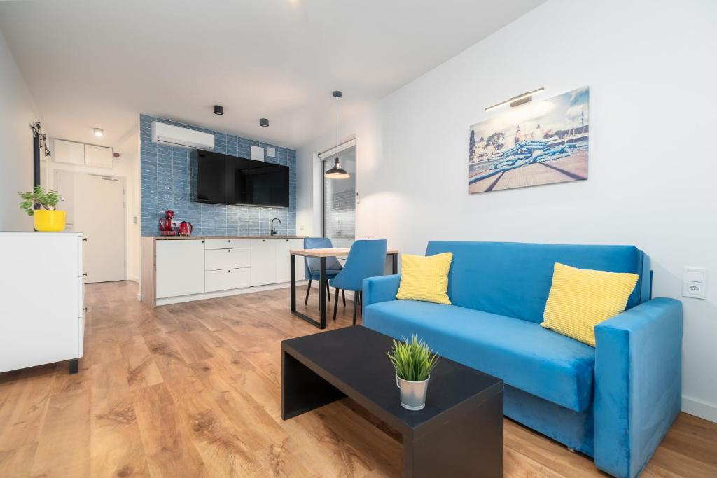 un soggiorno con divano blu e tavolo di Apartament Figo a Stettino