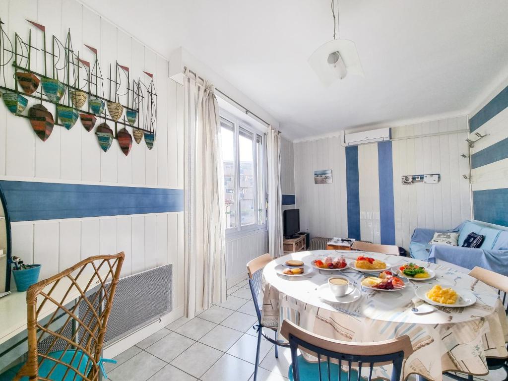 une salle à manger avec une table sur laquelle se trouve de la nourriture dans l'établissement Brice Marine - T4 climatisé en centre-ville, au Lavandou