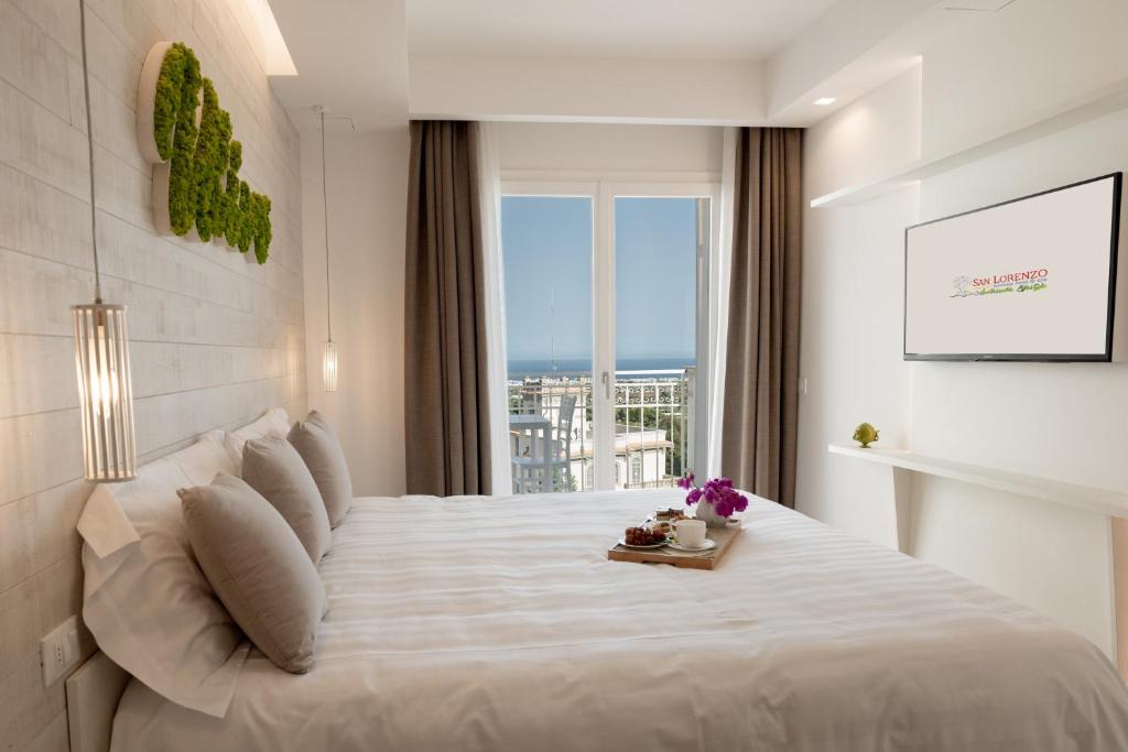 a bedroom with a large white bed with a window at San Lorenzo Boutique Hotel & SPA in Polignano a Mare