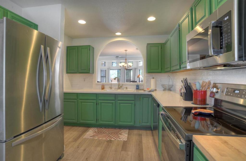 uma cozinha com armários verdes e um frigorífico de aço inoxidável em Fountain Hills Bungalow West em Fountain Hills