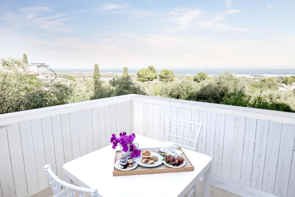 a white table with a plate of food on a balcony at San Lorenzo Boutique Hotel & SPA in Polignano a Mare