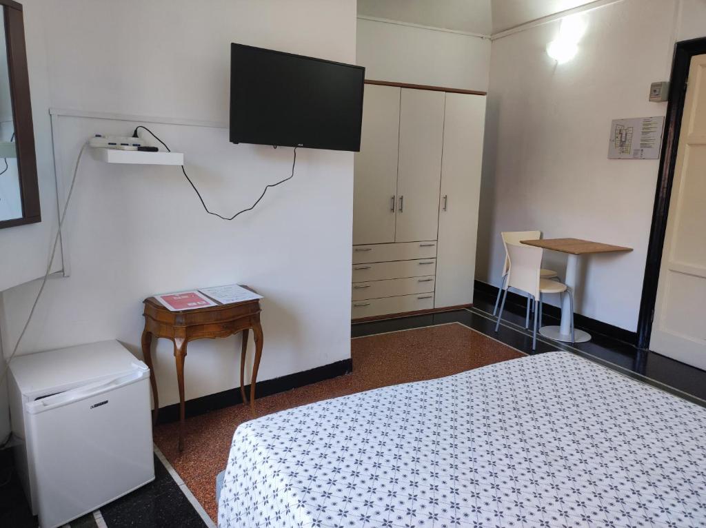 1 dormitorio con 1 cama y TV en la pared en Albergo Caffaro, en Génova