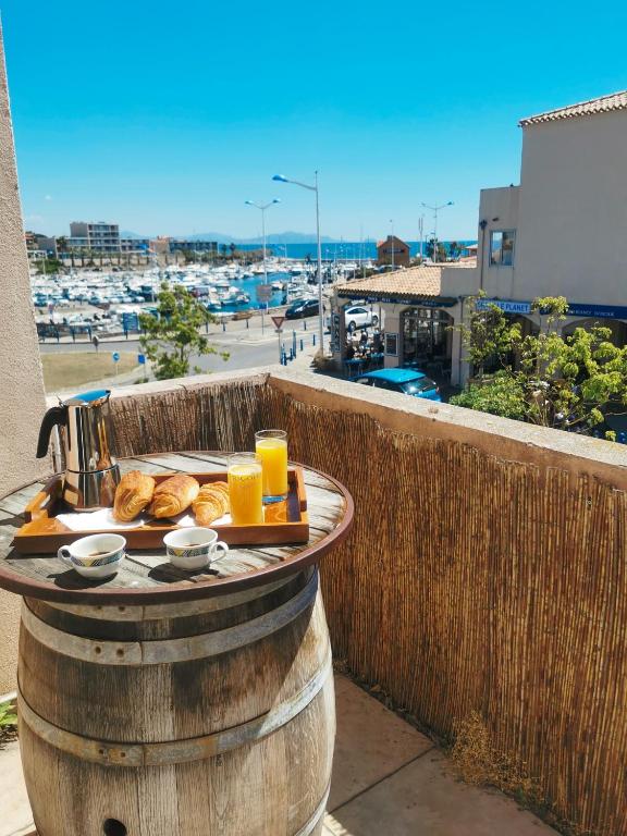 - un plateau de pain et de jus d'orange au-dessus d'un fût dans l'établissement Terrasse vue Mer et port, hyper centre, à Sausset-les-Pins
