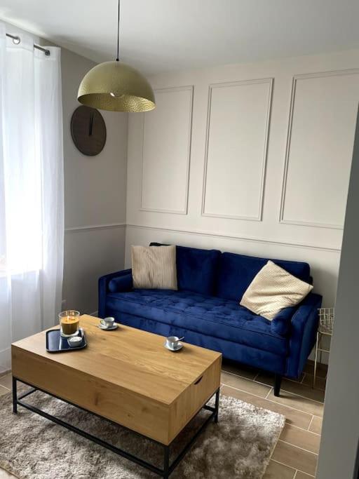 a living room with a blue couch and a coffee table at Bleu Suprême balnéo in Vierzon