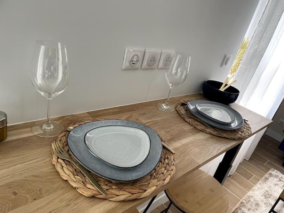 a table with two plates and two wine glasses at Bleu Suprême balnéo in Vierzon