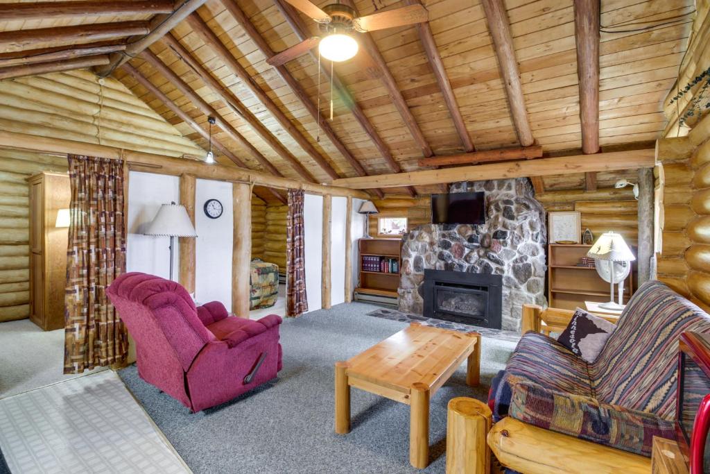 a living room with a fireplace in a log cabin at Rustic Bemidji Cabin with Boat and Lake Access! in Bemidji
