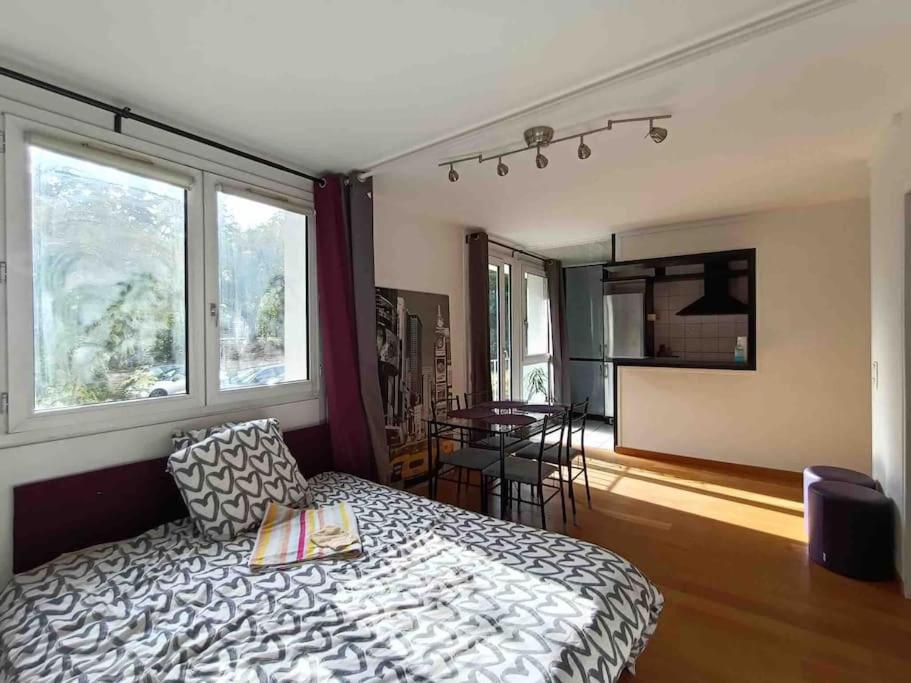 Appartement 6 invités à 25 min du centre de Paris في كاشان: غرفة نوم بسرير وطاولة ونوافذ