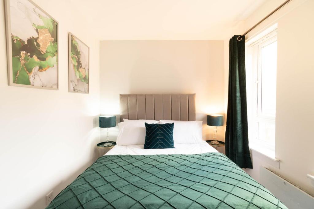 a bedroom with a bed with a green blanket at Glasgow City, West End, Private Parking in Glasgow