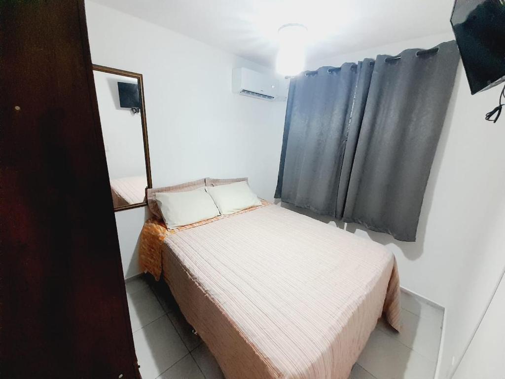 Habitación pequeña con cama y ventana en APTO - 2 quartos com ar condicionado - piscina disponível, en Campo Grande