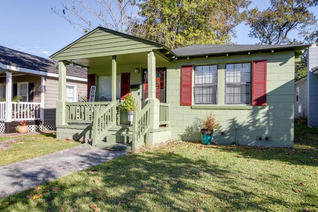 a green house with red shutters and a porch at Savannah Home with Yard about 3 Mi to Downtown! in Savannah