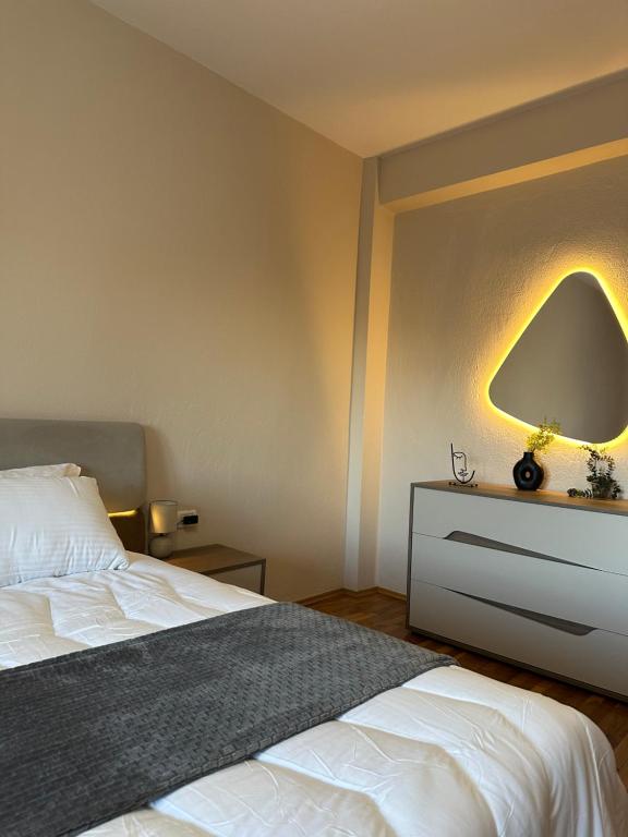 een slaapkamer met een bed met een lamp aan de muur bij Villa Malo Guesthouse in Korçë