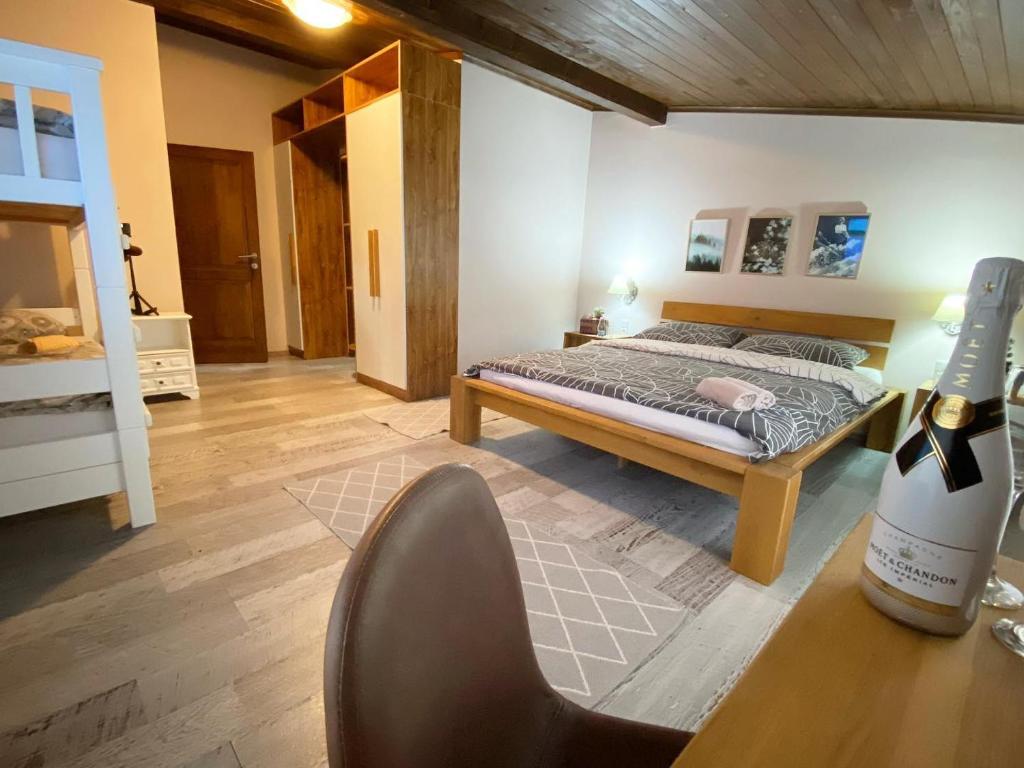 ein Schlafzimmer mit einem Bett und einer Flasche Wein in der Unterkunft Pansion Čarolija Vlašić in Šišava