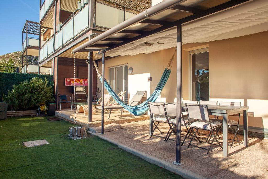 a patio with a table and chairs and a hammock at L évasion in Marseille