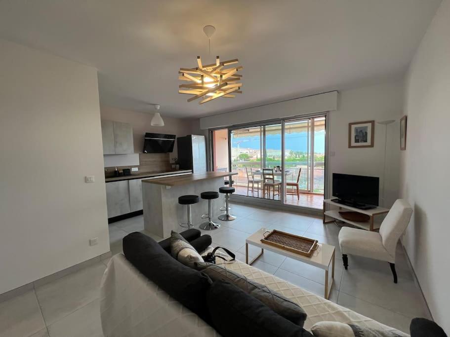 un salon avec un canapé et une cuisine dans l'établissement Très bel appartement centre-ville pour 4 personnes, à La Londe-les-Maures