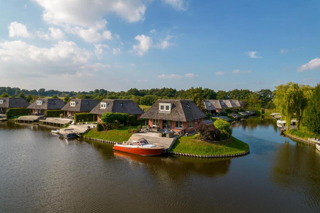 eine Luftansicht auf einen Fluss mit Häusern und einem Boot in der Unterkunft Summio Waterpark De Bloemert in Zuidlaren