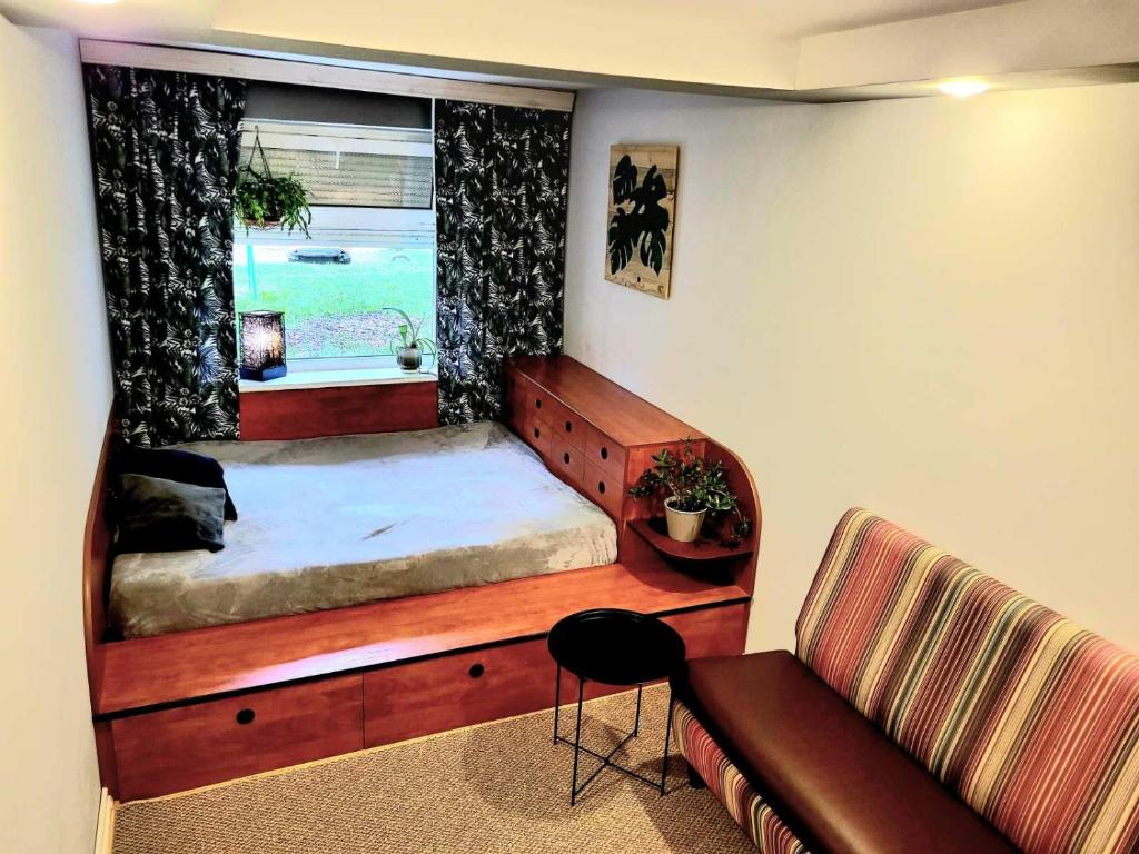 a bedroom with a bed and a couch and a window at Новая квартира in Uzhhorod