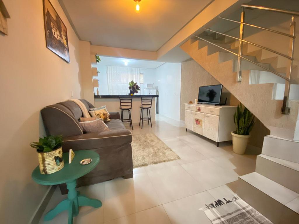 uma sala de estar com um sofá e uma mesa em Oasis Urbano em Goiânia
