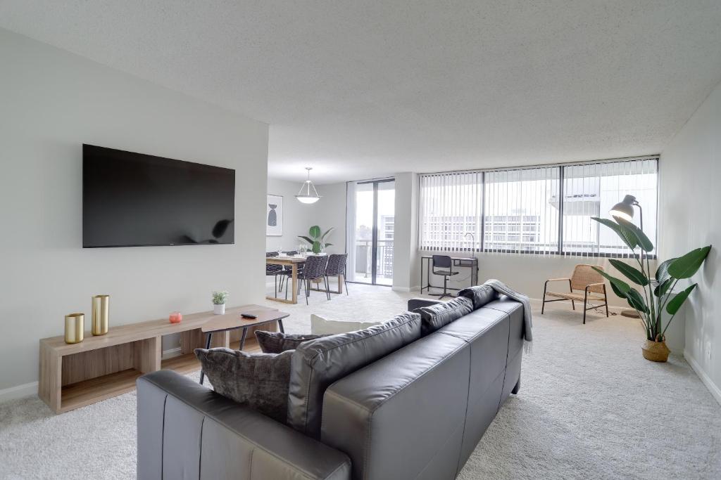 a living room with a couch and a tv at Located Crystal City Apt with Dazzling Amenities in Arlington