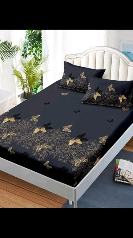 a bed with a black comforter with butterflies on it at Desandu Walawwa Resort in Kurunegala
