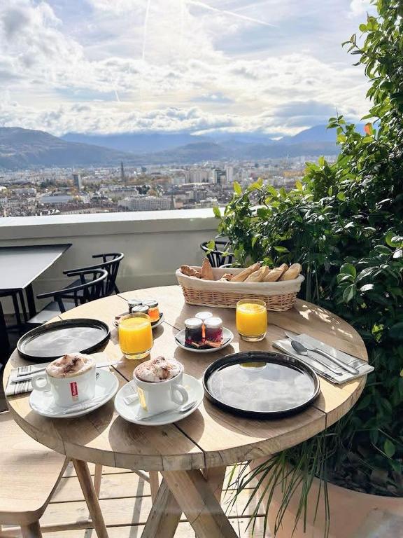 a wooden table with food and drinks on a balcony at Les Appartements de Grenoble in Grenoble