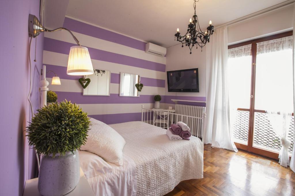 Dormitorio púrpura con cama y maceta en B&B Villa Ngiolò "vista mare", en Ancona