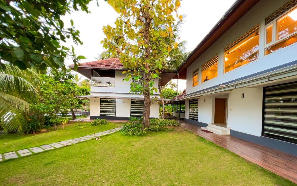 a house with a yard in front of it at Jai Lake House in Perumbalam