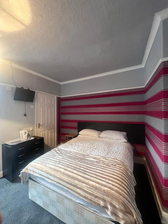ein Schlafzimmer mit einer rot-weißen gestreiften Wand in der Unterkunft No 1 Lord Street in Blackpool