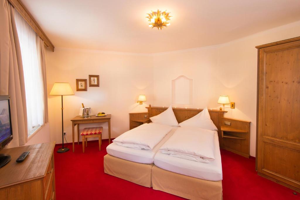A bed or beds in a room at Hotel Dachstein