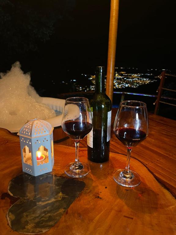 una mesa con dos copas de vino y una botella de vino en Senderos Glamping en Villavicencio