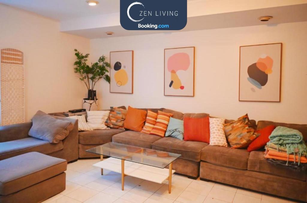 a living room with a brown couch with colorful pillows at Brooklyn Gem, 3-Bed Retreat , Relocation & Business Stay - Zen Living Short Term Rental in Brooklyn