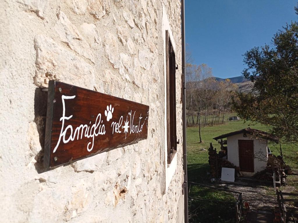 un cartello sul lato di un edificio in pietra di Famiglia nel vento a Caramanico Terme