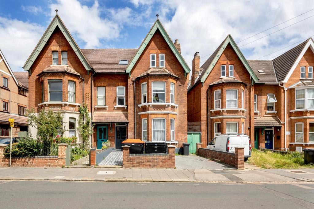 a large brick house on the side of a street at 1BR Victorian House near Bedford City Centre in Bedford