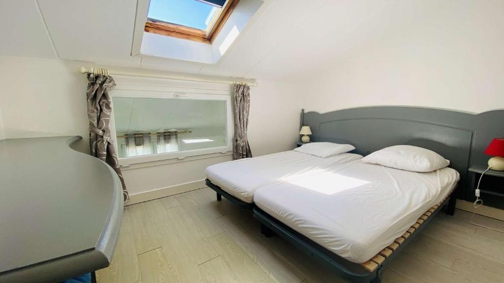 a bedroom with a bed and a window in it at A proximité du cinéma et du marché, à 150 m de la plage in La Couarde-sur-Mer