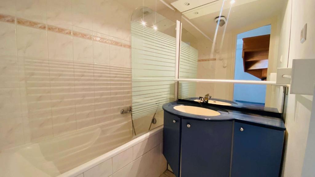 a bathroom with a sink and a shower and a tub at A proximité du cinéma et du marché, à 150 m de la plage in La Couarde-sur-Mer