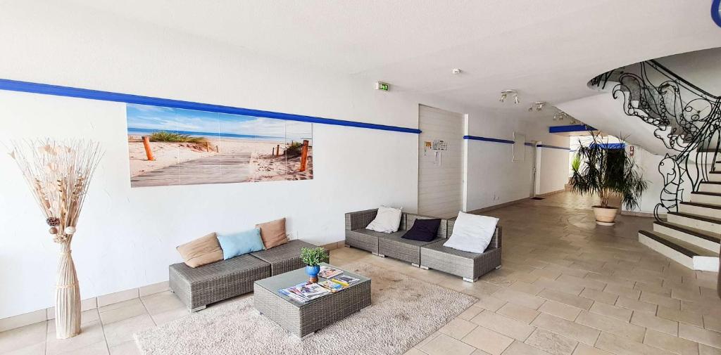 a living room with two couches and a table at A proximité du cinéma et du marché, à 150 m de la plage in La Couarde-sur-Mer