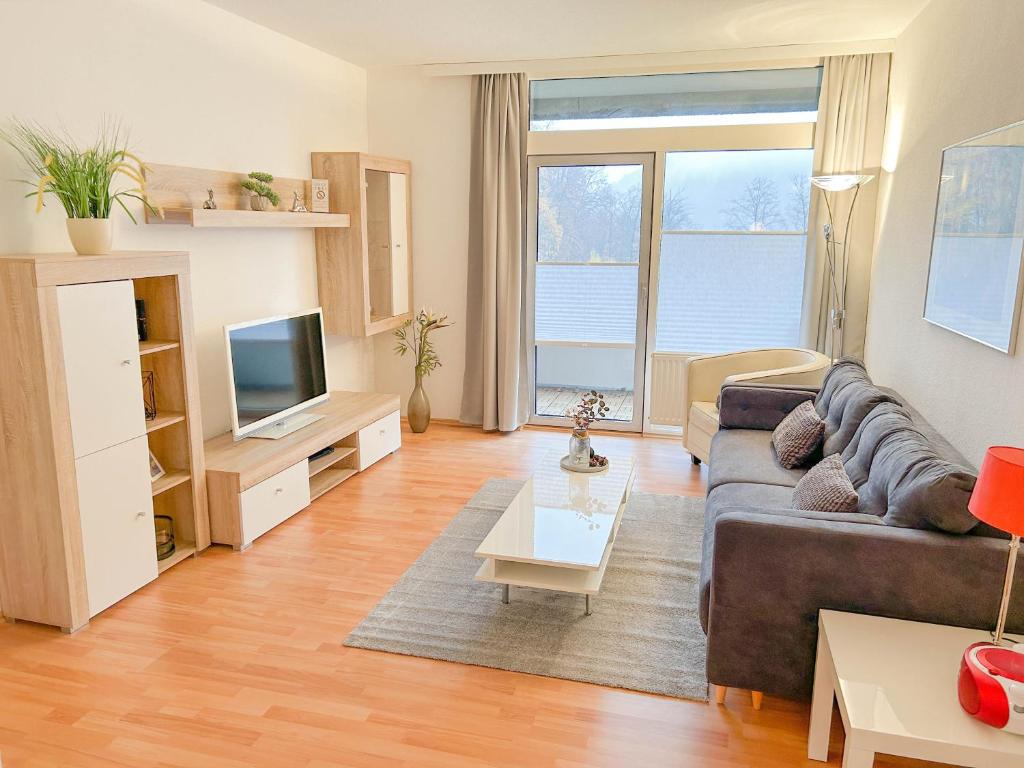 ein Wohnzimmer mit einem Sofa und einem TV in der Unterkunft Waldoase II inkl Sauna-und Schwimmbadnutzung in Bad Harzburg