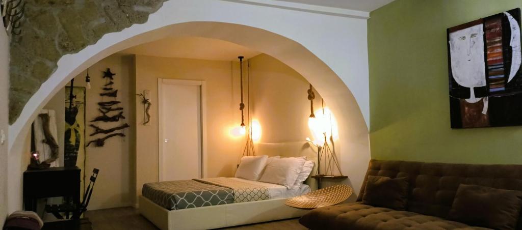 ナポリにあるLa 'NZIRIAのベッドルーム1室(ベッド1台付)、アーチ型の出入り口が備わります。