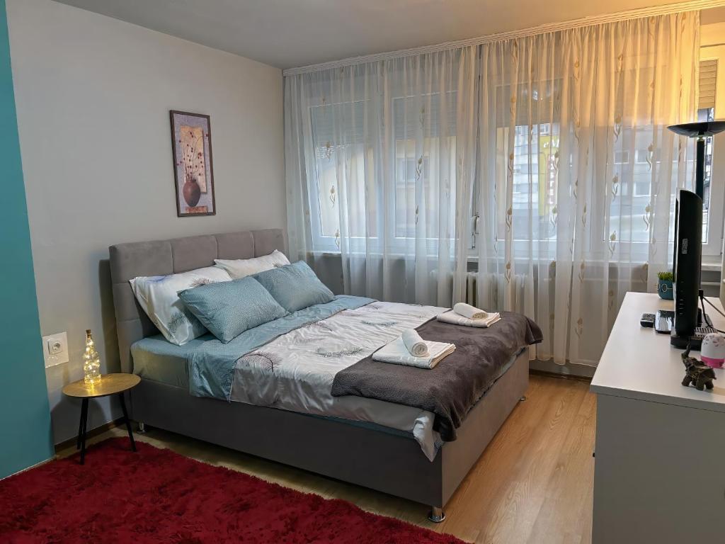 Schlafzimmer mit einem Bett, einem Schreibtisch und einem TV in der Unterkunft Apartment Gataric Banja Luka in Banja Luka