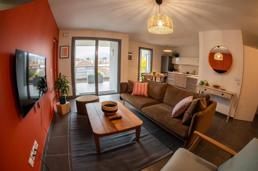 a living room with a couch and a table at La Ruche des carrés - T3 vue panoramique in Annecy