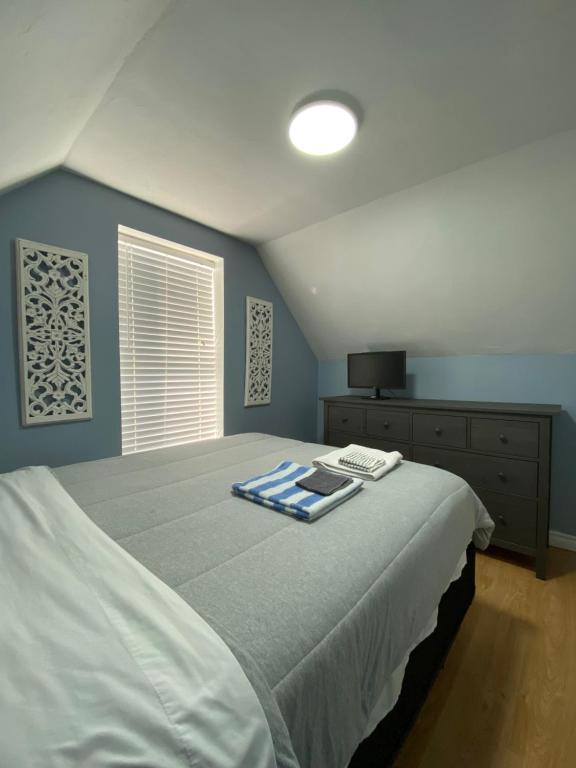 a bedroom with a bed with a blue wall at Private Room- Shediac Beach House in Shediac