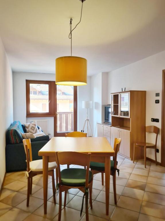 - une cuisine et une salle à manger avec une table et des chaises dans l'établissement La Dimora delle Dolomiti - Pinzolo, à Pinzolo