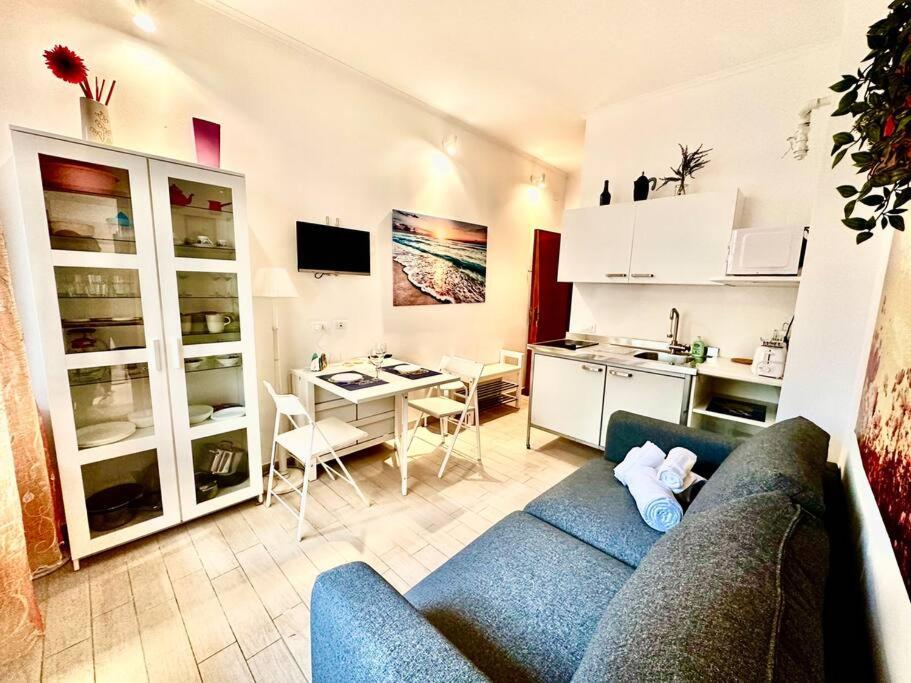 a living room with a blue couch and a kitchen at Suite Rapallo Centro - Mare & Wifi in Rapallo