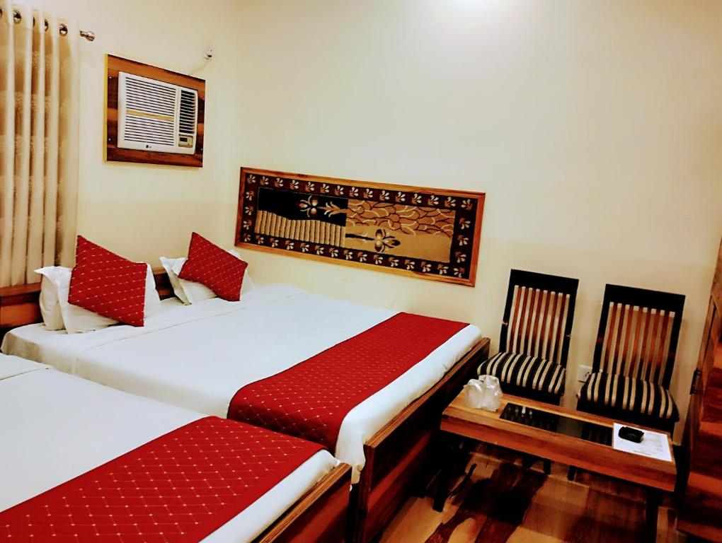 two beds in a room with red pillows at Bhagyashree Guest House in Varanasi