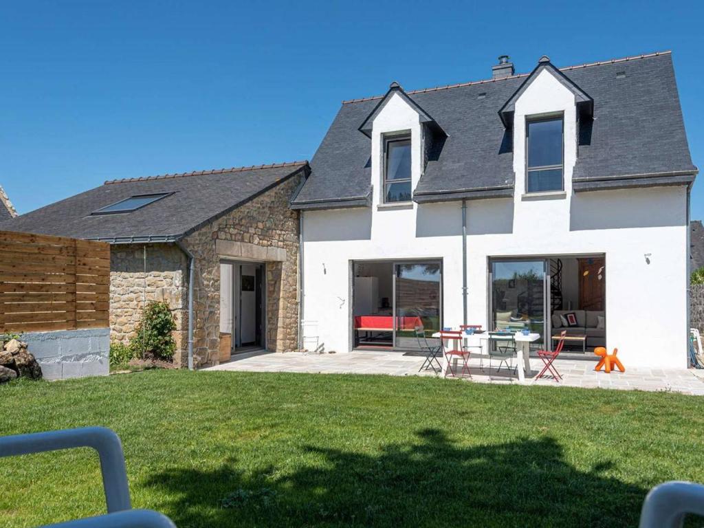 une maison blanche avec une table dans une cour dans l'établissement Villa 4P avec jardin, Wifi, à 500m des plages - Carnac - FR-1-477-159, à Carnac