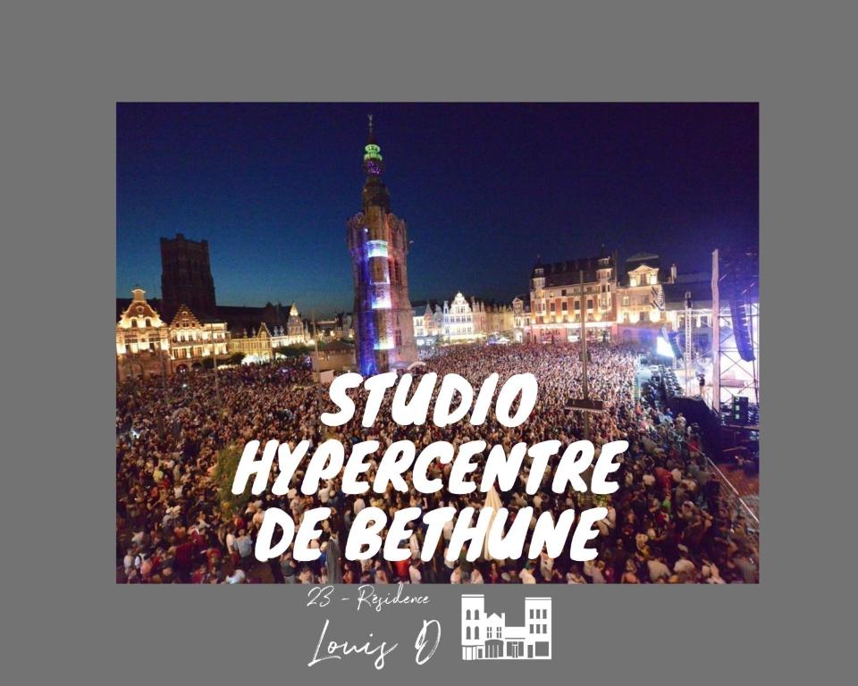 una multitud de personas frente a una torre de reloj por la noche en Studio pour 2 Personnes --3, en Béthune